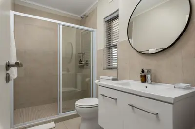 a bathroom with a toilet and a sink and a mirror at Mayfair 134 in Cape Town