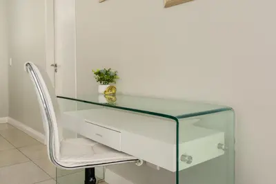 a glass desk with a chair in a room at Mayfair 134 in Cape Town