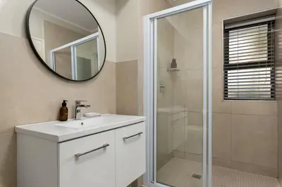 a bathroom with a white sink and a mirror at Mayfair 134 in Cape Town