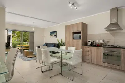 a kitchen and dining room with a table and chairs at Mayfair 134 in Cape Town