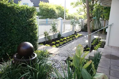 a garden with a white fence and a stone walkway at Cape Robin Cottage in Franschhoek