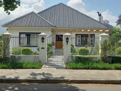 a white house with a gate in front of it at Spacious Modern Home, Paarl Winelands in Paarl