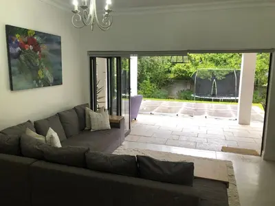 a living room with a couch and a patio at Spacious Modern Home, Paarl Winelands in Paarl