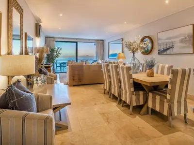 a dining room and living room with a table and chairs at 74 on Marine in Hermanus