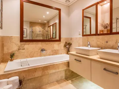 a bathroom with two sinks and a tub and a mirror at 74 on Marine in Hermanus