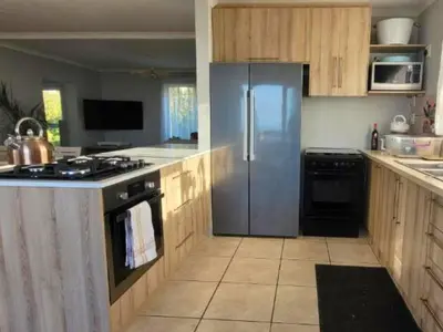 a kitchen with a stainless steel refrigerator and a stove at Silvertree Collective Ocean and Mountain View in Bettyʼs Bay