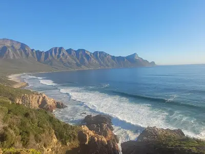 a view of the ocean with mountains in the background at Silvertree Collective Ocean and Mountain View in Bettyʼs Bay