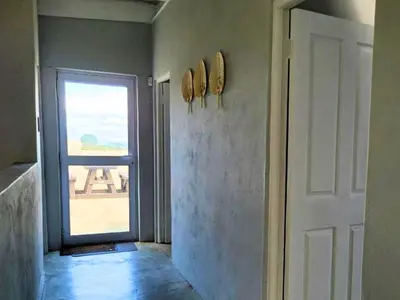 a hallway with a door and a window with a view at Silvertree Collective Ocean and Mountain View in Bettyʼs Bay