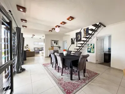 a dining room and living room with a table and chairs at Cheap Affordable Self-Catering Double Room with Pool, WiFi and Braai in Cape Town