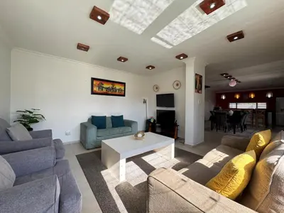 a living room with couches and a table in it at Cheap Affordable Self-Catering Double Room with Pool, WiFi and Braai in Cape Town