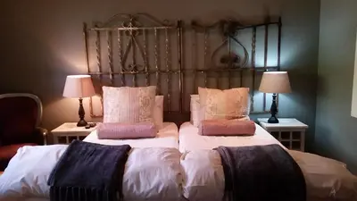 a bedroom with two beds with pillows and two lamps at Simondium's Country Lodge in Simondium