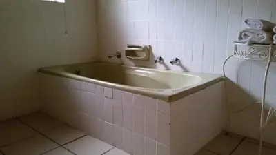 a bathroom with a sink and towels on the wall at Simondium's Country Lodge in Simondium