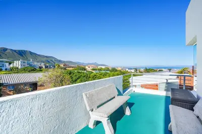 a bench on the balcony of a house at Vermont Dreamcatcher in Hermanus