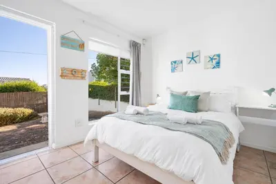 a bedroom with a bed and a large window at Vermont Dreamcatcher in Hermanus