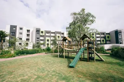 a playground in front of a large building at Apartments on Century in Cape Town