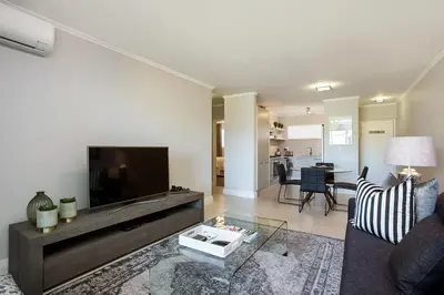 a living room with a couch and a tv at Apartments on Century in Cape Town