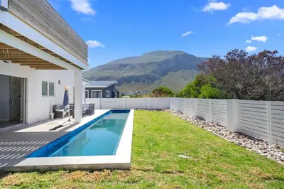 a backyard with a swimming pool and a fence at Metalasia Four in Bettyʼs Bay