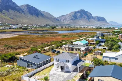 an aerial view of a village with houses and mountains at Metalasia Four in Bettyʼs Bay
