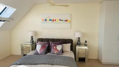a bedroom with a bed with purple pillows at Dolphin Beach Penthouse in Cape Town