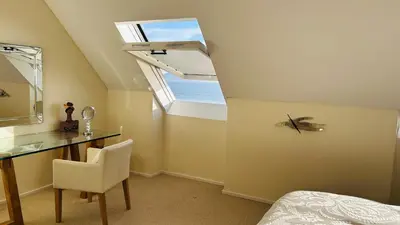 a bedroom with a desk and a window at Dolphin Beach Penthouse in Cape Town