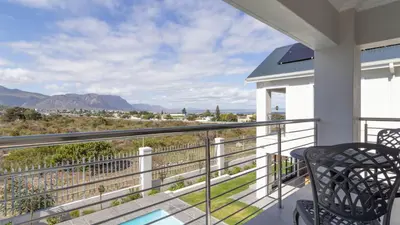 a balcony with a view of the mountains at Ocean Whisper Villa near Westcliff coastal paths in Hermanus