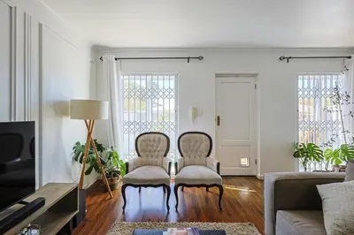 a living room with two chairs and a couch at Fully Equipped Claremont Home with Pool & Style in Cape Town