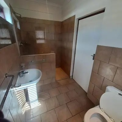 a bathroom with a tub and a sink and a toilet at Overnight Lodge in Cape Town