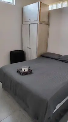 a bedroom with a bed with a book on it at Kenwyn Micro Cottage in Cape Town