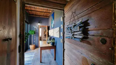 a hallway with blue walls and a wooden door at Klein-Hangklip Remote Mountain Studio Cottage in Rooiels