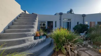 a house with concrete stairs in front of it at Klein-Hangklip Remote Mountain Studio Cottage in Rooiels