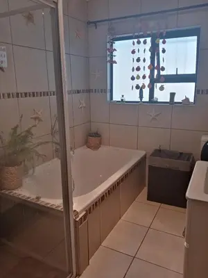 a bath tub in a bathroom with a window at Home in Bellville, Cape Town in Victory Hill