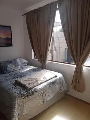 a bedroom with a bed and a window with curtains at Home in Bellville, Cape Town in Victory Hill