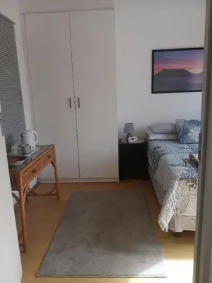 a bedroom with a bed and a table with a table sidx sidx at Home in Bellville, Cape Town in Victory Hill