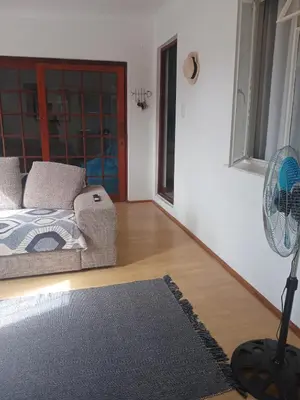 a living room with a couch and a fan at Home in Bellville, Cape Town in Victory Hill