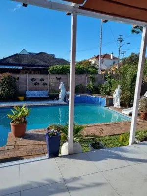 a swimming pool with two statues in a yard at Fully Furnished Room and en-suite in Cape Town