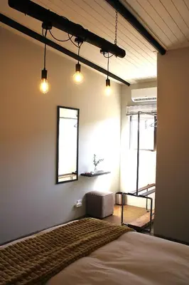 a bedroom with a bed and a window and lights at Lategansrus at Helpmekaar Farm in Wellington