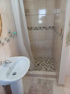 a bathroom with a sink and a shower at Stylish Studio in Tableview Stay in Cape Town