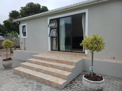 a house with stairs in front of a house at Stylish Studio in Tableview Stay in Cape Town