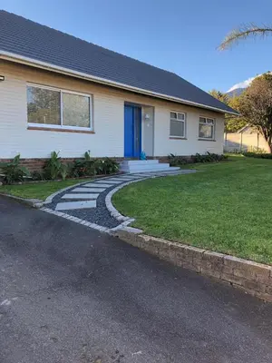 a house with a blue door and a driveway at Three on Firmount in Somerset West