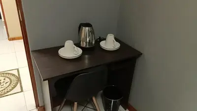 a table with two plates and a coffee maker on it at Springforth Guesthouse in De Grendel