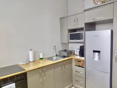 a kitchen with a white refrigerator and a sink at The Botanic High Gold in Paarl