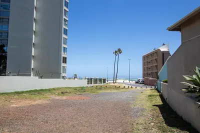 an empty street next to a building and the beach at Mountain View Coastal Retreat in Strand