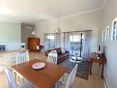 a kitchen and living room with a table and chairs at Helderberg Hideaway Loft in Somerset West