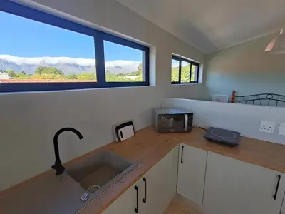 a kitchen with a sink and a window at Helderberg Hideaway Loft in Somerset West