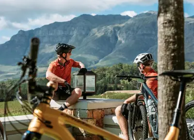 two men with helmets on sitting next to a television at Helderberg Hideaway Loft in Somerset West