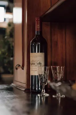 a bottle of wine sitting on a table with two glasses at The Crescent Hideaway in Franschhoek