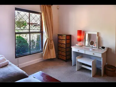 a room with a desk with a mirror and a window at The Manor House at Roubaix Estate in Franschhoek