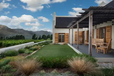 a house with a patio and a lawn at Skaap huis in Sir Lowryʼs Pass