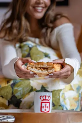 a woman is holding a sandwich in her hands at Paarl Boutique Hotel in Paarl