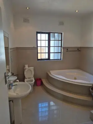 a bathroom with a tub and a toilet and a sink at Pine House - self-catering in Cape Town